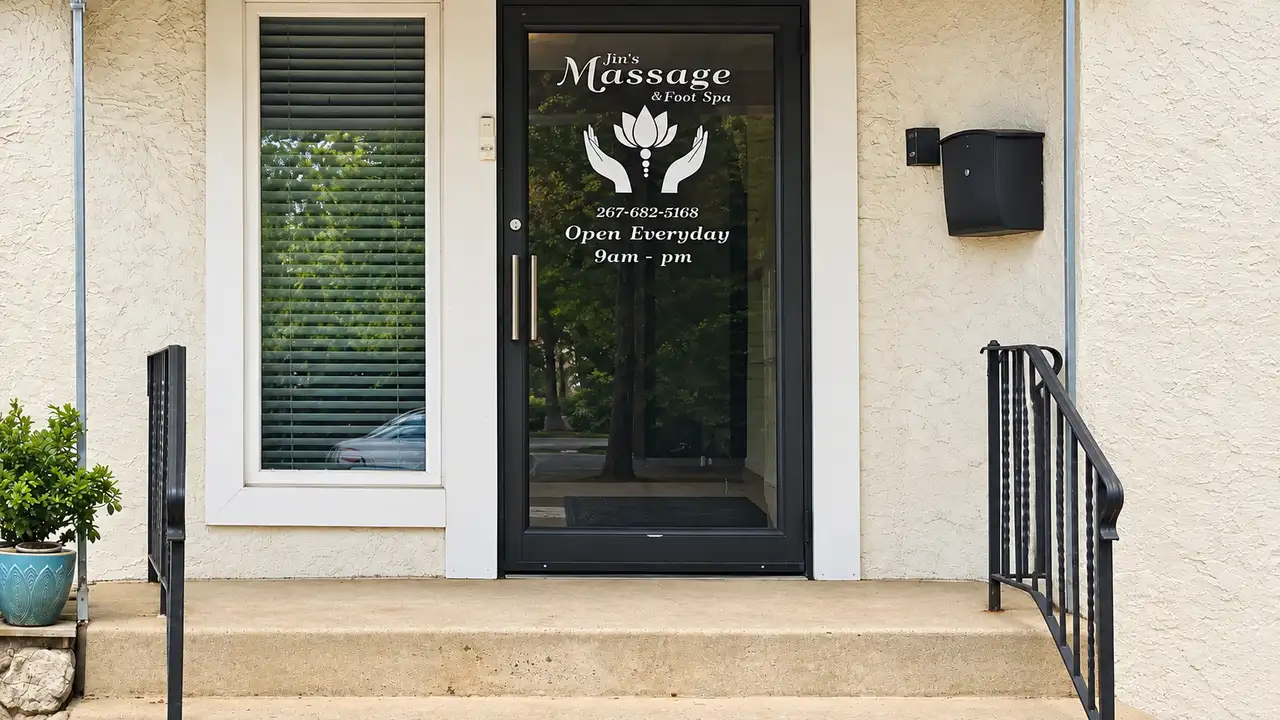 Entrance with a Jin’s Massage glass door and steps leading up to it