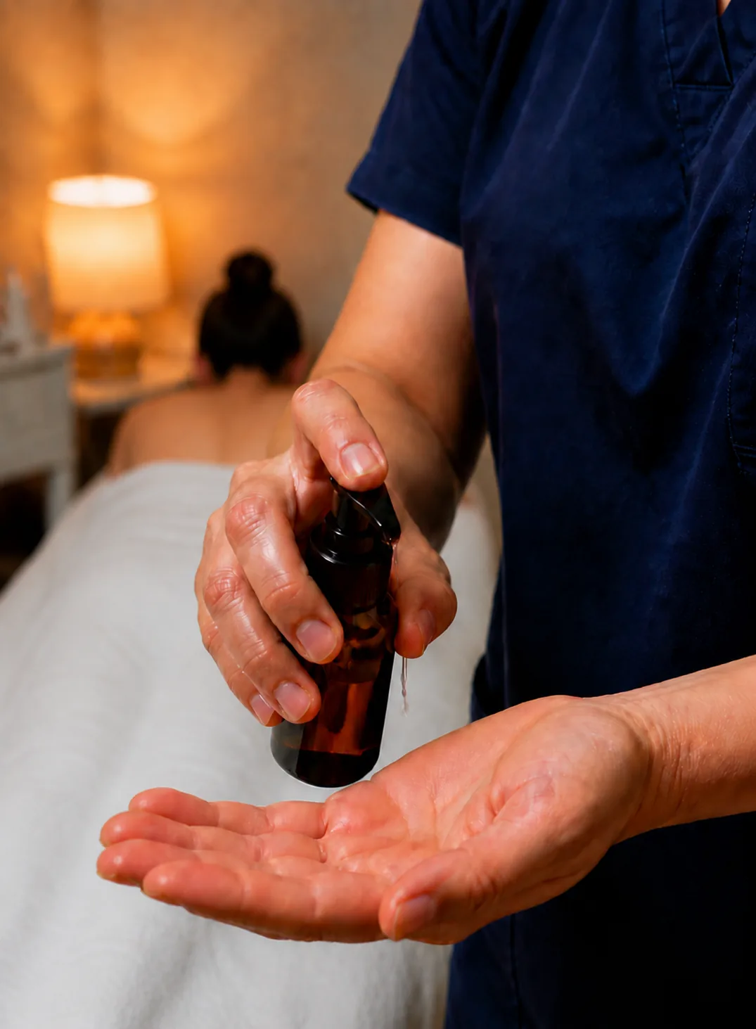 Massage oil being prepared beside a treatment table